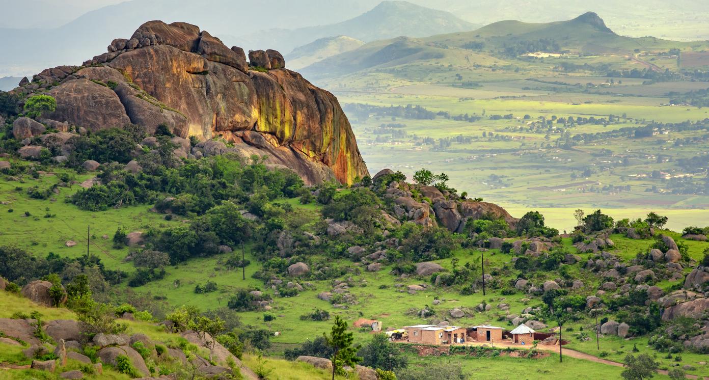 Ezulwini valley in Swaziland eSwatini with beautiful mountains, trees and rocks in scenic green valley between Mbabane and Manzini cities. Traditional huts houses of Swaziland