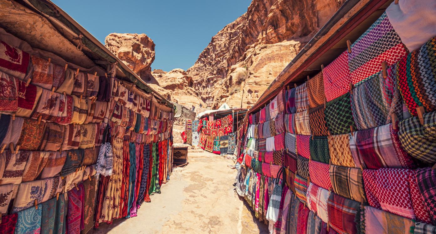 Shopping street with market in the ancient city of Petra in Jordan with souvenir products, fabrics and carpets with national Bedouin ornaments