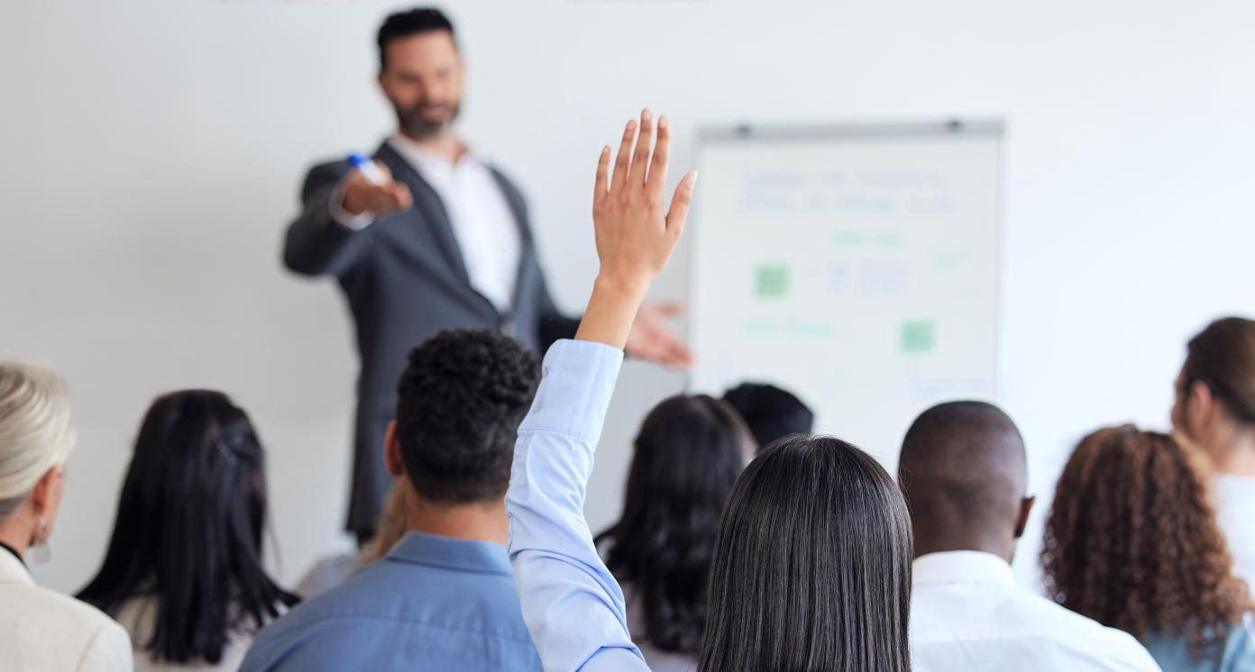 Train the Trainer mage page image of a student raising her hand in a course