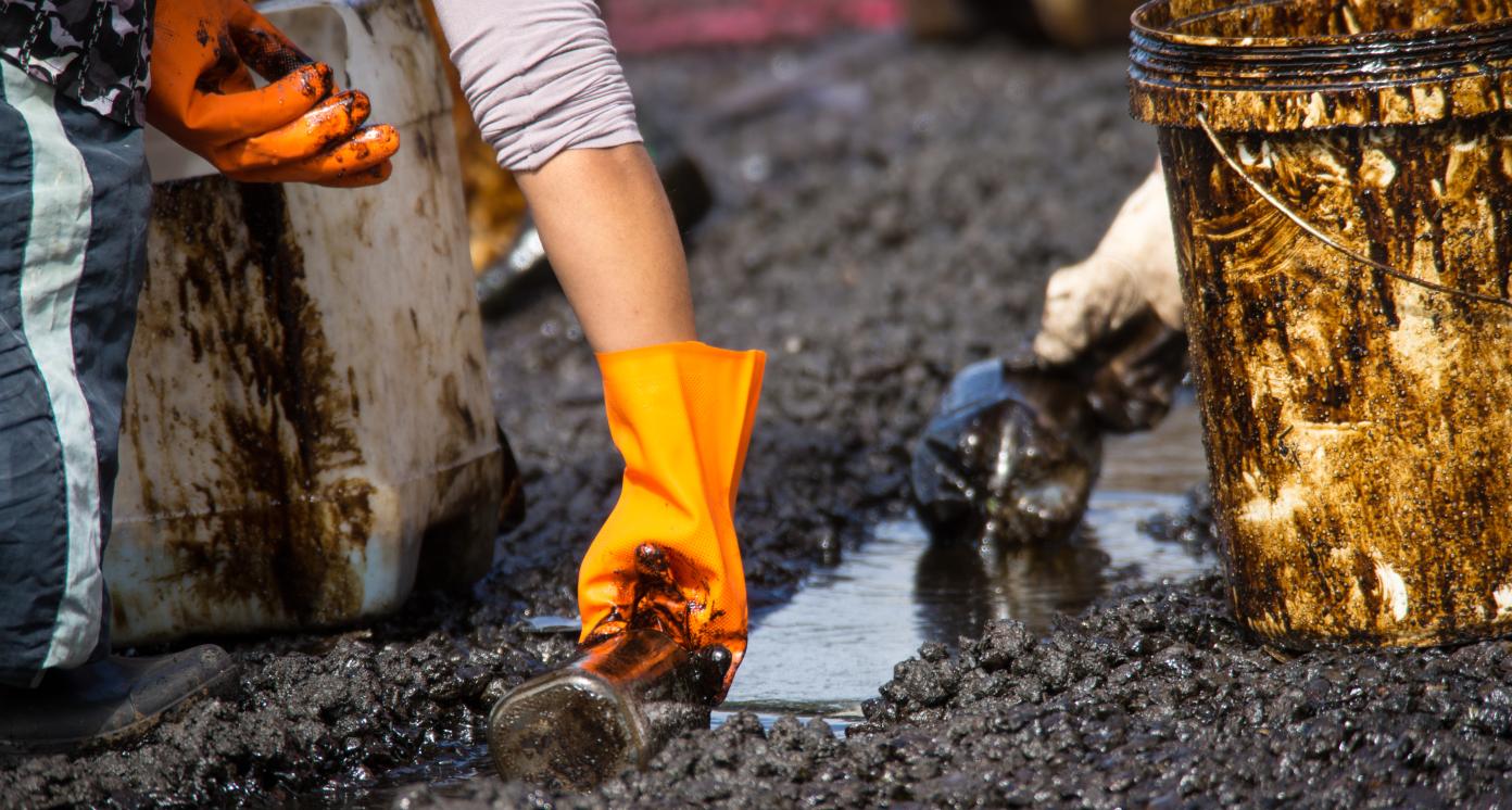 Volunteers clean the ocean coast from oil after a tanker wreck. Mauritius