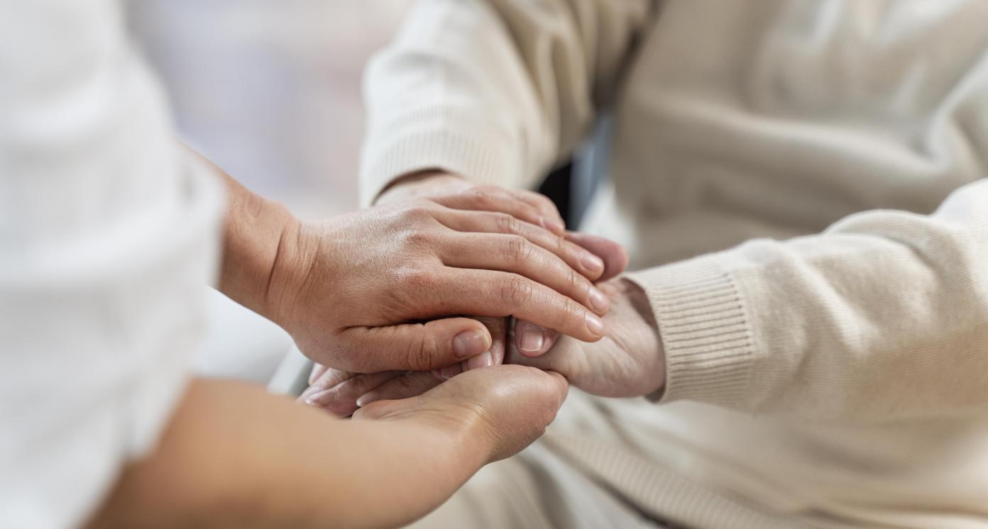 Doctor holding hands of a senior patient