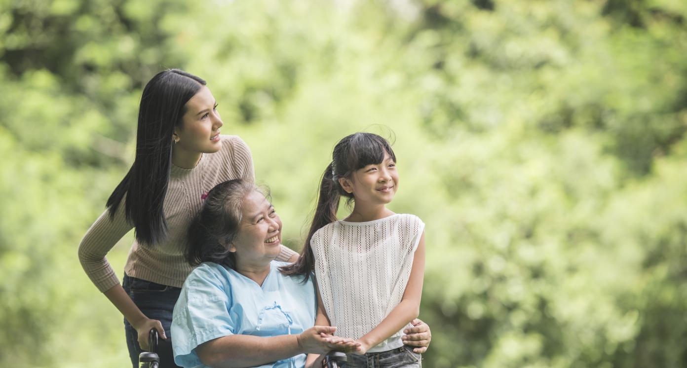 Happy grandmother in wheelchair with daughter and grand daughter