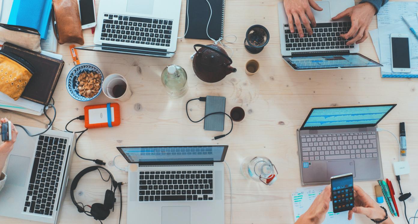 People sitting around a table with laptops