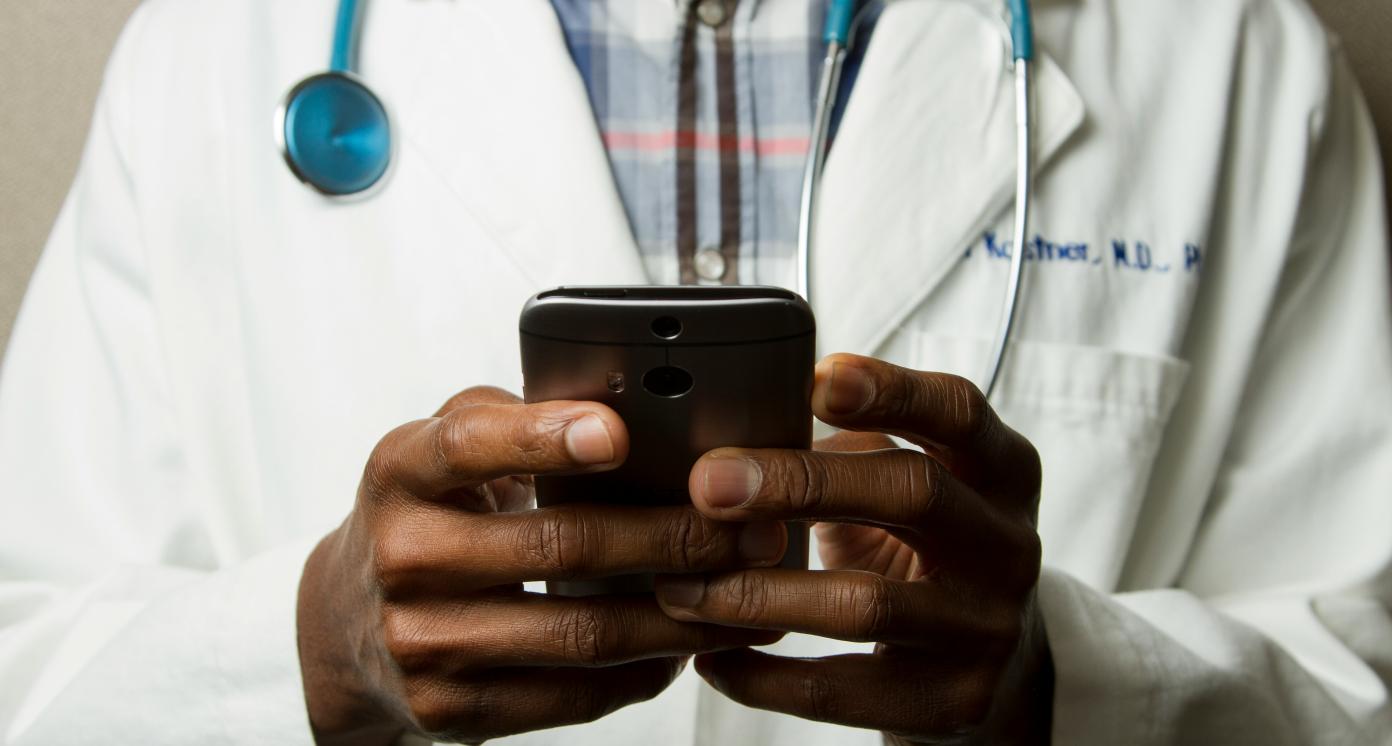 Doctor wearing stethoscope and using phone