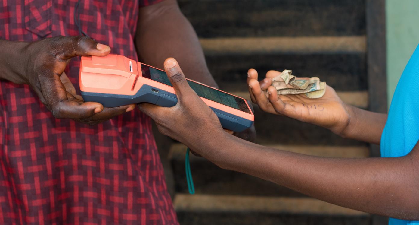 Hands of two african individuals doing business transaction with point of sales terminal know as POS machine in Nigeria