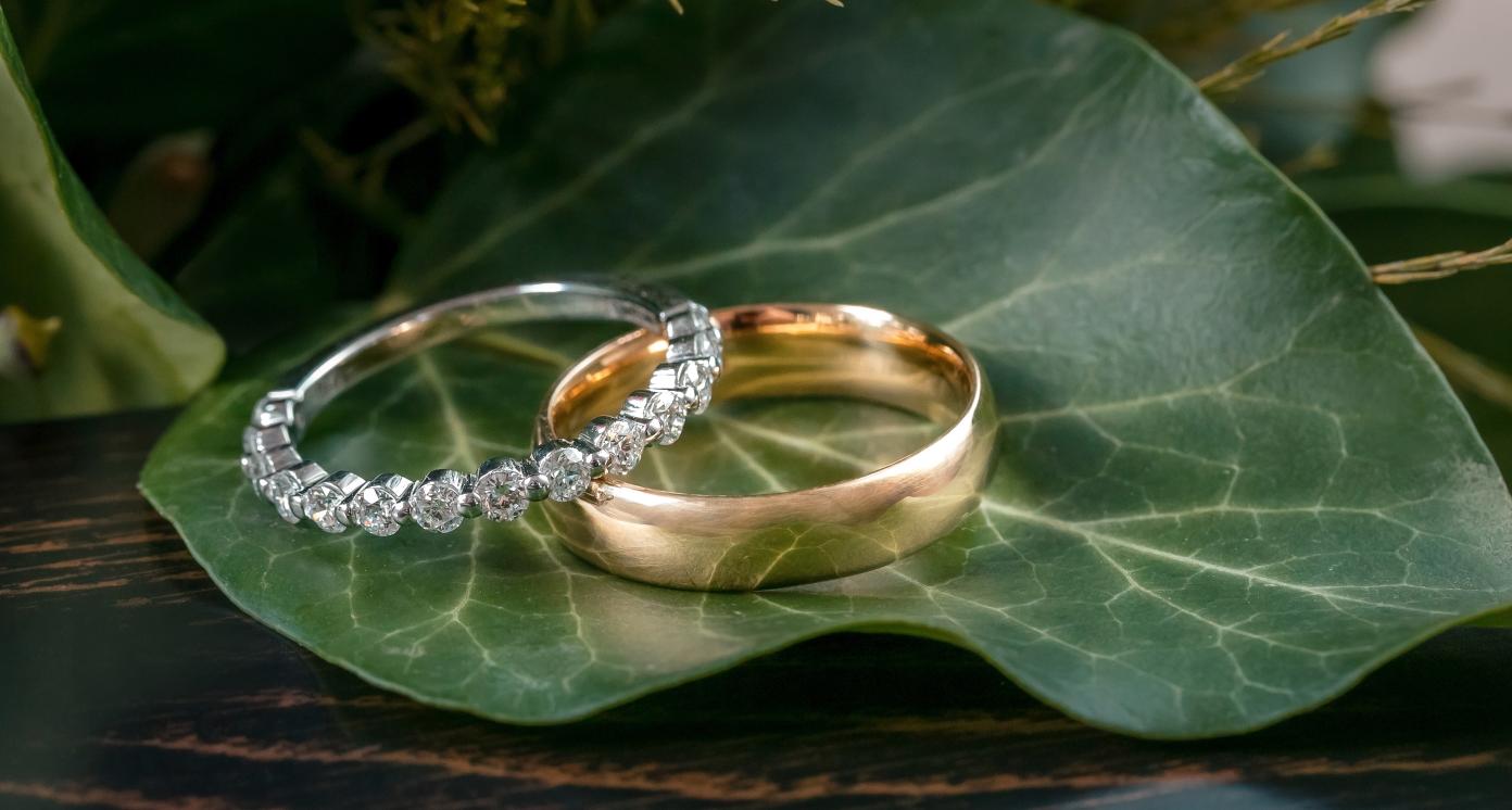 Golden Wedding Rings on Leaf and Wood Background