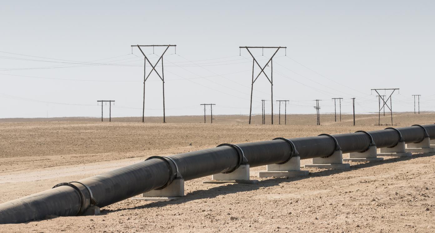 Oil, gas or water pipeline and electricity pylons in the desert, concept for energy transmission, Namibia, Africa