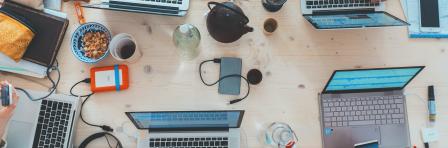 People sitting around a table with laptops