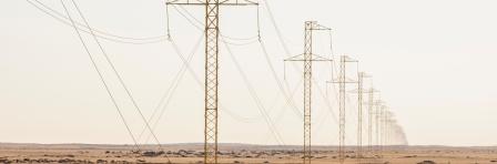 Electricity pylons stretch out as far as you can see, showing the curvature of the earth. Namib Desert, Namibia