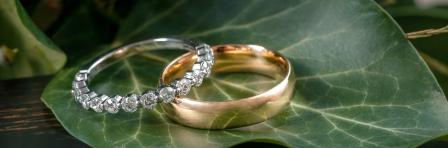 Golden Wedding Rings on Leaf and Wood Background