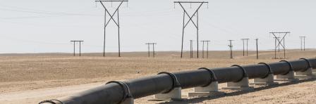 Oil, gas or water pipeline and electricity pylons in the desert, concept for energy transmission, Namibia, Africa